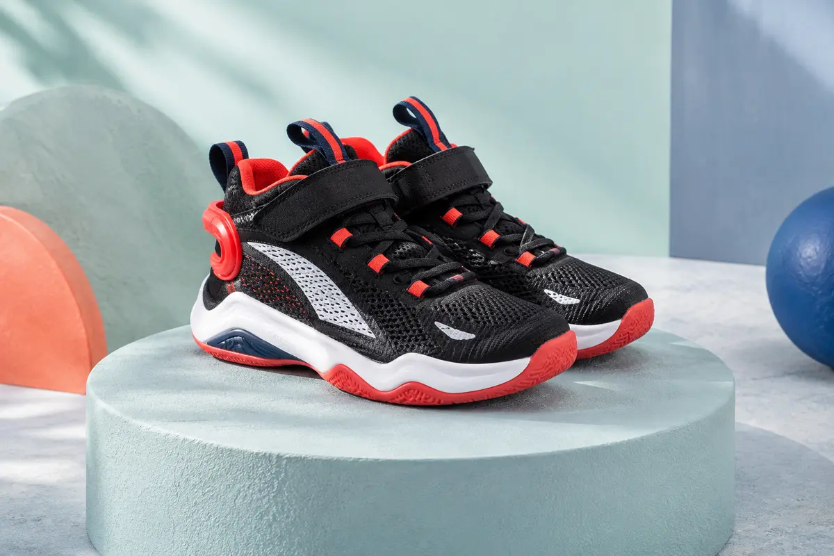 Baskets de basketball enfant en mesh noir, avec accents rouges, détails blancs et fermeture à scratch