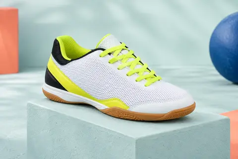 Chaussure de futsal Adidas pour enfant, en mesh blanc, noir et jaune, sur un socle mat