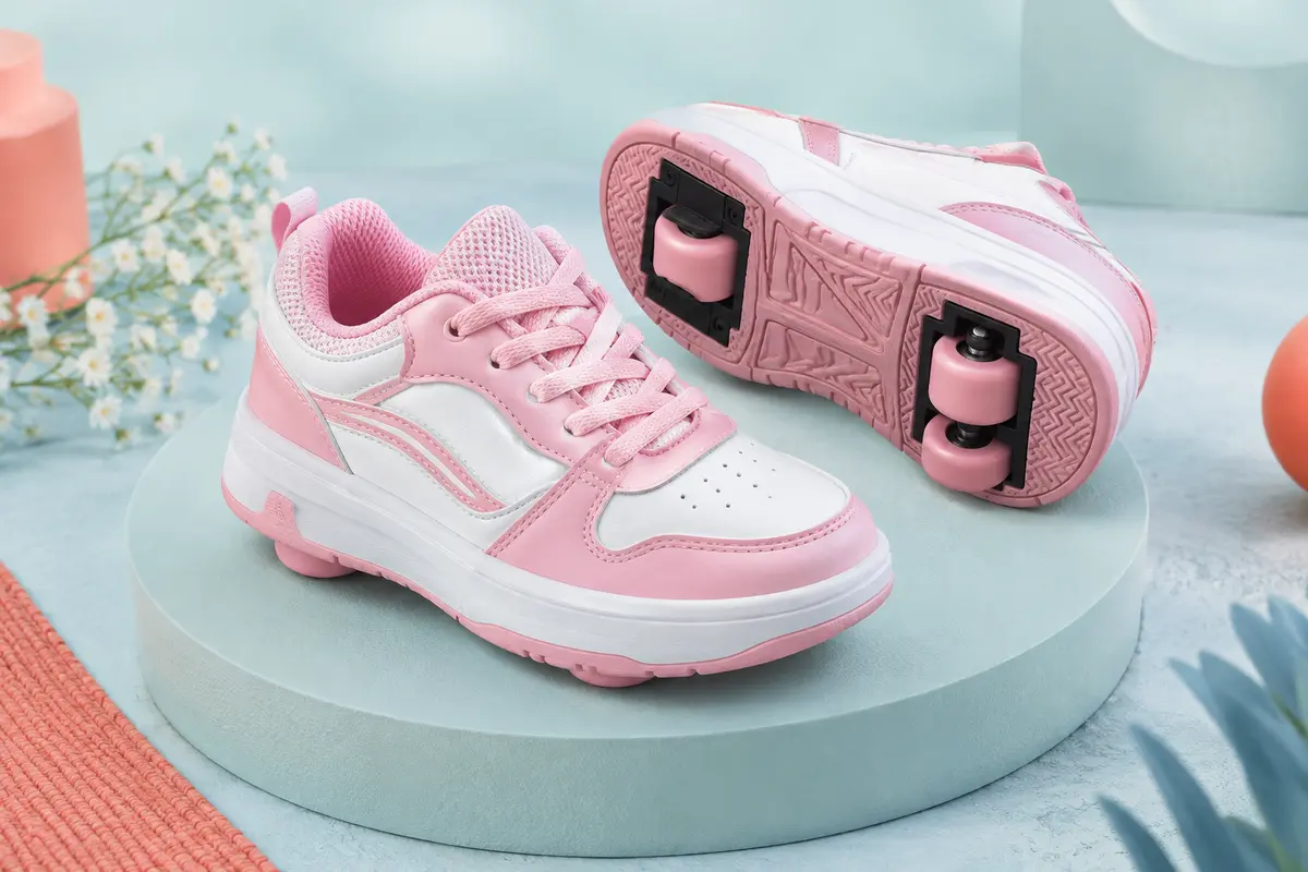 Baskets enfant rose et blanc à roues amovibles, présentées seules sur un socle clair