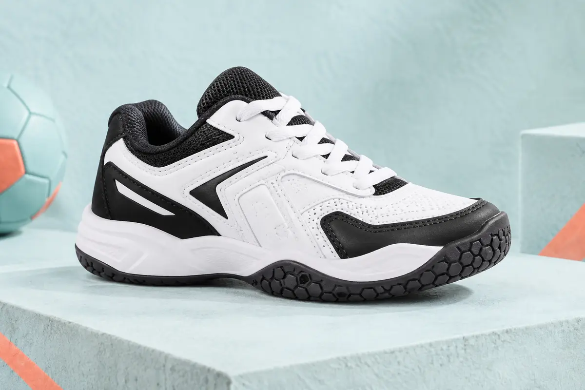 Chaussure basse de handball enfant blanche et noire avec semelle extérieure à motif hexagonal