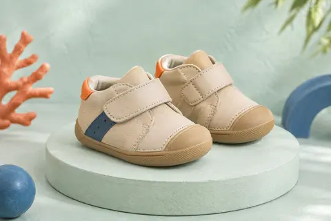 Paire de chaussures premiers pas bébé beige avec fermeture à scratch et semelle en caoutchouc
