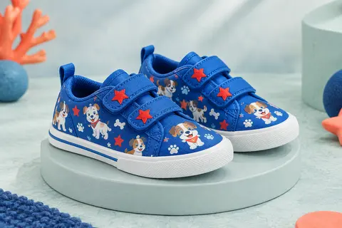Baskets lumineuses Paw Patrol en toile bleue, avec deux brides, des motifs de chiots et des étoiles rouges.