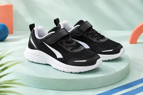 Paire de baskets de running Puma pour enfant, en maille noire avec des détails blancs