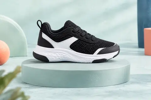 Paire de baskets enfant noires et blanches en mesh, avec semelle en EVA et zones en caoutchouc.