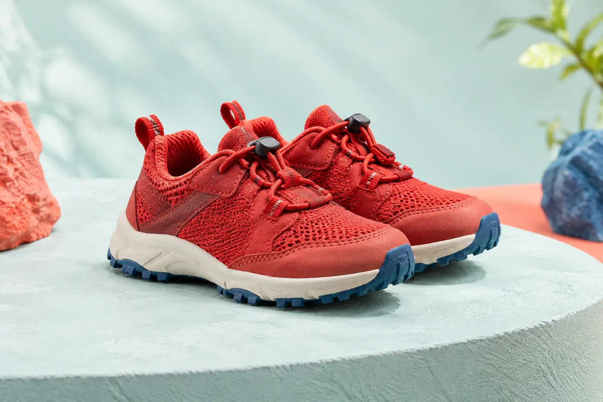 Paire de chaussures de trail enfant rouges en maille, avec avant-pied spacieux et semelles en caoutchouc.