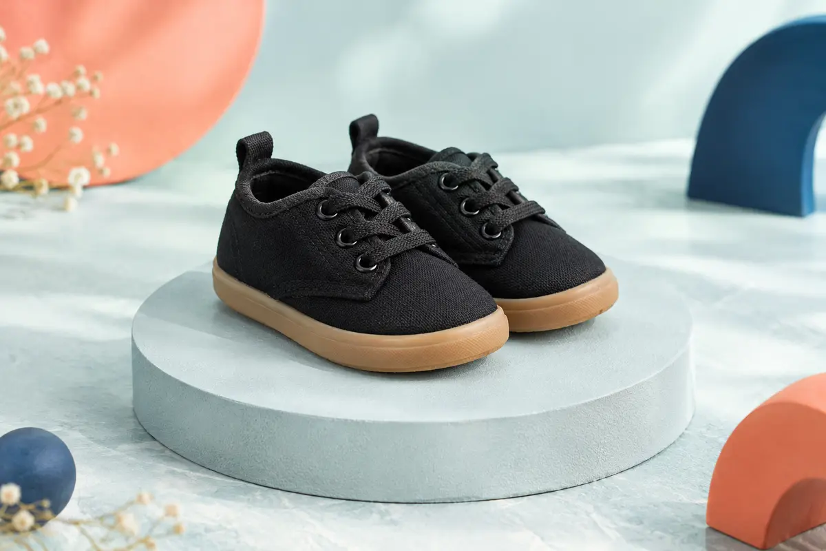 Paire de baskets basses noires en toile pour tout-petits, avec lacets et semelle souple