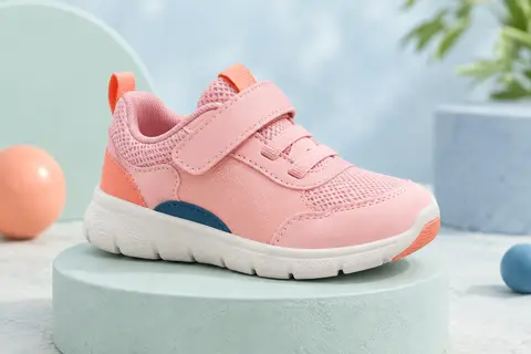 Basket enfant rose à bout large, fermeture à boucle et semelle souple présentée sur un socle mat
