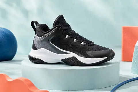 Chaussure de basketball junior noire, gris jais et blanche présentée seule sur un socle mat